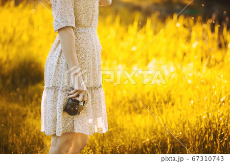 girl photographer in a sunny meadow with a retro camera takes pictures girl photographer in a sunny meadow with a retro camera takes pictures 67310743