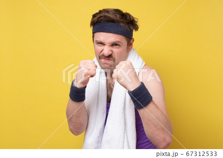 positive young man posing with clenched fists in studio positive young man posing with clenched fists in studio 67312533