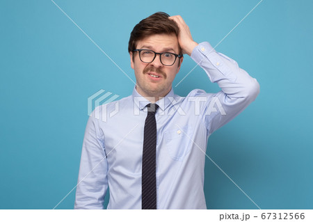 Young businessman puzzled trying to make a hard decision 67312566