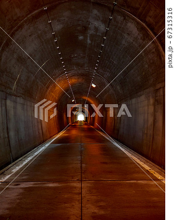 明かりに照らされているが、薄暗いトンネルの構内 67315316