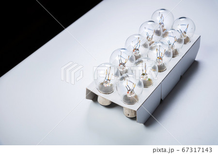 New incandescent car lamps for car sizes in paper-packed lot on a grey gradient background New incandescent car lamps for car sizes in paper-packed lot on a grey gradient background 67317143