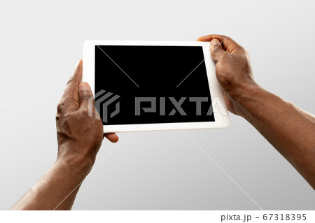 Close up male hands holding tablet with blank screen during online watching of popular sport matches and championships all around the world. Copyspace for ad 67318395