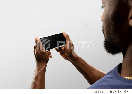 Close up male hands holding smartphone with blank screen during online watching of popular sport matches and championships all around the world. Copyspace for ad Close up male hands holding smartphone with blank screen during online watching of popular sport matches and championships all around the world. Copyspace for ad 67318443