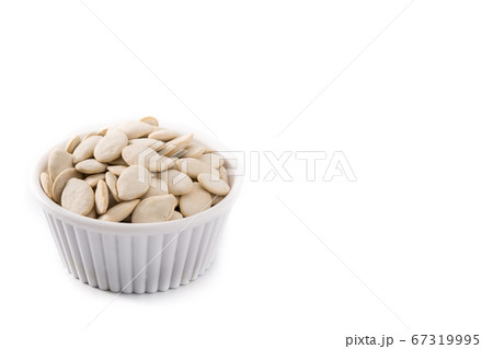 Pumpkin seeds in bowl isolated on white background Pumpkin seeds in bowl isolated on white background 67319995