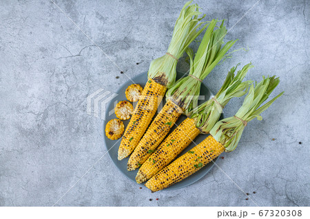 Grilled sweet corn cobs with herbs, salt and spices 67320308