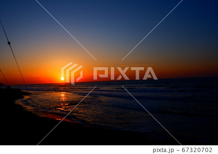 水平線に沈みゆく日本海の夕日 67320702