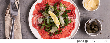 Marbled beef carpaccio with arugula, capers, lemon Marbled beef carpaccio with arugula, capers, lemon 67320909