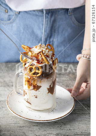 Creamy vanilla milky shake with pretzels in a white saucer 67326154