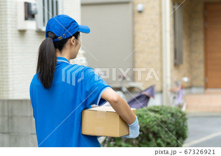 荷物を届ける宅配便の若い女性ドライバー 荷物を届ける宅配便の若い女性ドライバー 67326921