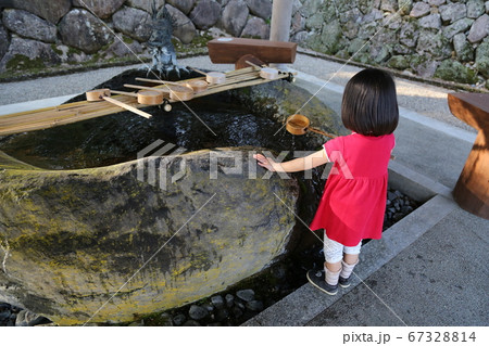 神社の手水舎で手を清める赤い服の女の子 神社の手水舎で手を清める赤い服の女の子 67328814