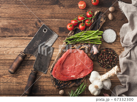Braising steak on chopping board with rosemary Braising steak on chopping board with rosemary 67332300