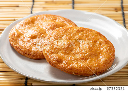 皿におかれたせんべい2枚。背景、すだれ。 皿におかれたせんべい2枚。背景、すだれ。 67332321