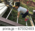 キャップをかぶってアスレチックで遊ぶ男の子 67332403