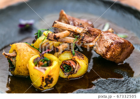 Roasted lamb ribs with stuffed potato on black 67332505