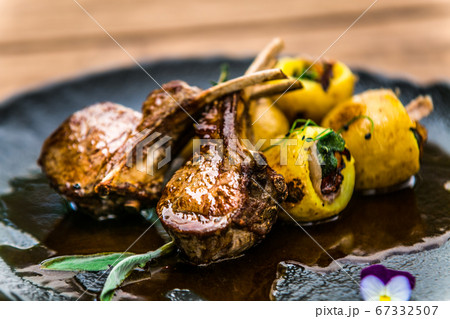 Roasted lamb ribs with stuffed potato on black 67332507