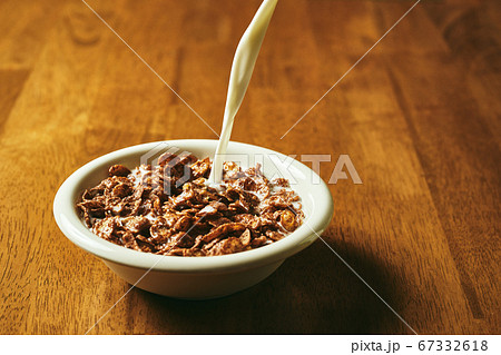 チョコレートフレークに牛乳を注いでいるところ チョコレートフレークに牛乳を注いでいるところ 67332618