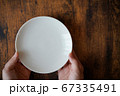 左によった白い皿と手 67335491