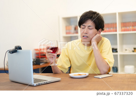 オンライン飲み会で嫌な顔をする若い男性 オンライン飲み会で嫌な顔をする若い男性 67337320