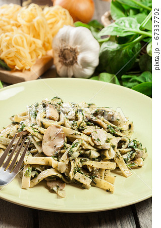 Tagliatelle pasta with spinach and mushrooms on a Tagliatelle pasta with spinach and mushrooms on a 67337702