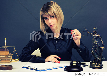 A young fair woman judge works in her office. A young fair woman judge works in her office. 67340066