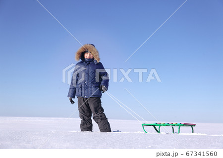 boy with sled on sky background boy with sled on sky background 67341560