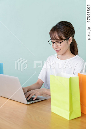 パソコンでオンラインショッピングをする若い女性 67343306