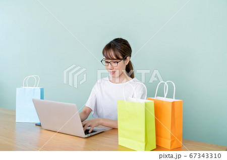 パソコンでオンラインショッピングをする若い女性 パソコンでオンラインショッピングをする若い女性 67343310