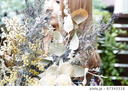 ドライフラワーと花柄のワンピースの巻き髪の女性と植物のフォトジェニックな写真 67343318