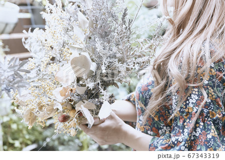 ドライフラワーと花柄のワンピースの巻き髪の女性と植物のフォトジェニックな写真 67343319