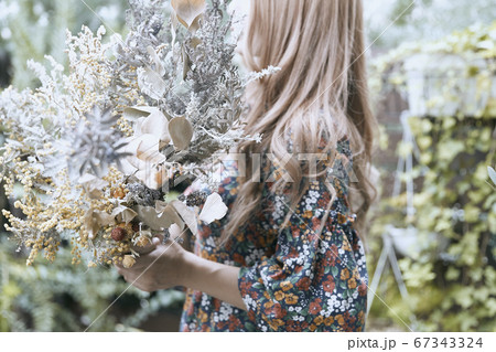ドライフラワーと花柄のワンピースの巻き髪の女性と植物のフォトジェニックな写真 ドライフラワーと花柄のワンピースの巻き髪の女性と植物のフォトジェニックな写真 67343324