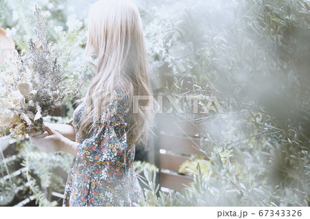 ドライフラワーと花柄のワンピースの巻き髪の女性と植物のフォトジェニックな写真 ドライフラワーと花柄のワンピースの巻き髪の女性と植物のフォトジェニックな写真 67343326