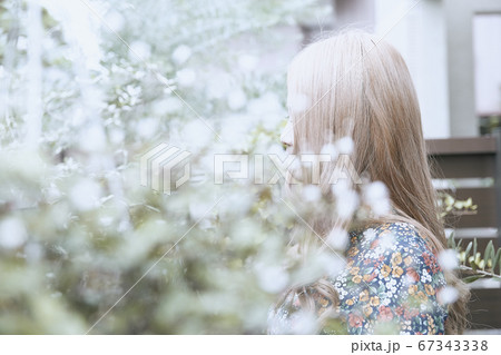 ドライフラワーと花柄のワンピースの巻き髪の女性と植物のフォトジェニックな写真の写真素材