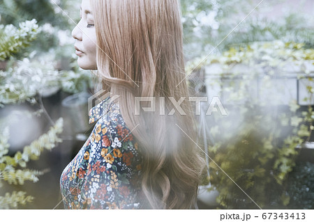 美しい髪の横顔の巻き髪の女性と植物背景のフォトジェニックな写真 美しい髪の横顔の巻き髪の女性と植物背景のフォトジェニックな写真 67343413