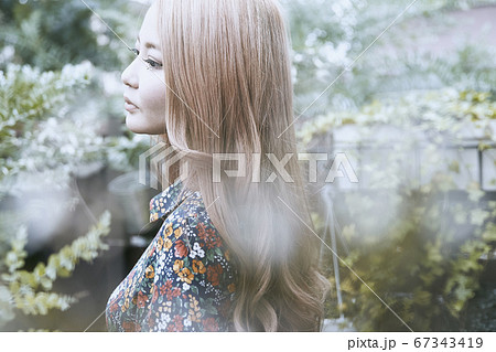 美しい髪の横顔の巻き髪の女性と植物背景のフォトジェニックな写真 美しい髪の横顔の巻き髪の女性と植物背景のフォトジェニックな写真 67343419