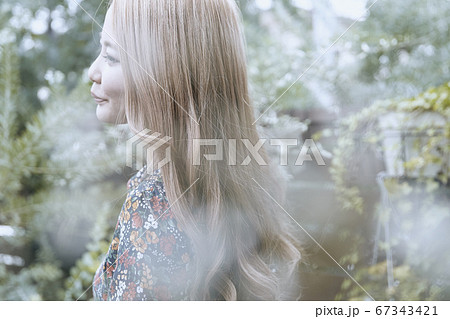 美しい髪の横顔の巻き髪の女性と植物背景のフォトジェニックな写真 67343421