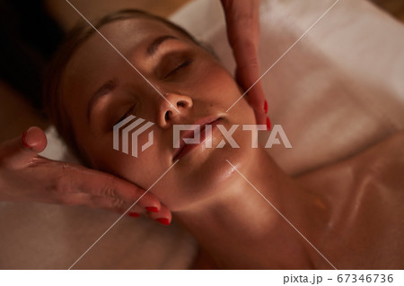 Hands of beautician touching the cheeks of young woman 67346736