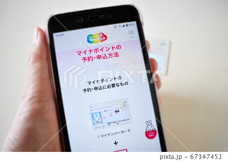手に持ったスマホのマイナポイント予約・申込画面 手に持ったスマホのマイナポイント予約・申込画面 67347451