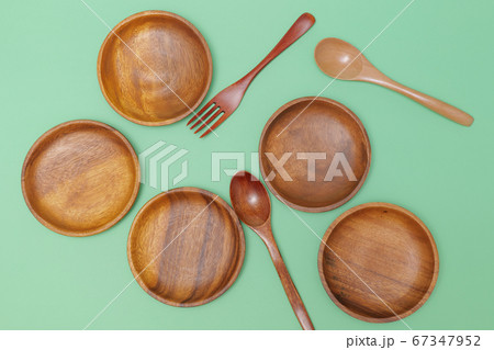 緑の背景に置いた丸い木製の皿 緑の背景に置いた丸い木製の皿 67347952