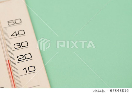 緑の背景のプラスチック製アナログ気温計 67348816