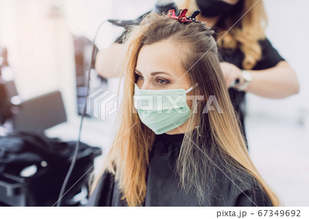 Woman visiting the hairdresser wearing face mask 67349692