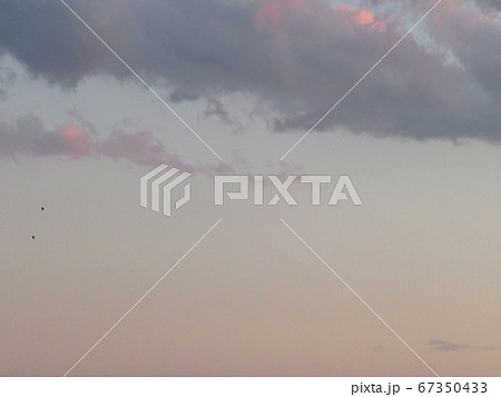 薄っすらピンク色に染まる夕焼け空の雲 の写真素材