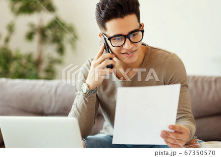 Positive freelancer speaking on smartphone on 67350570