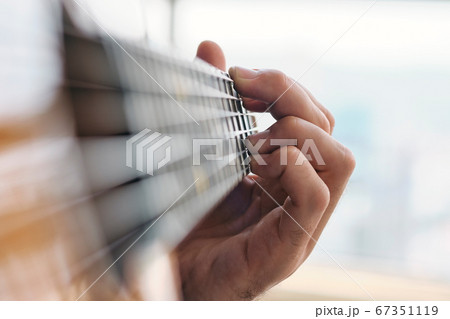 Close-up Of Man Practising Chords With Classical Guitar Close-up Of Man Practising Chords With Classical Guitar 67351119