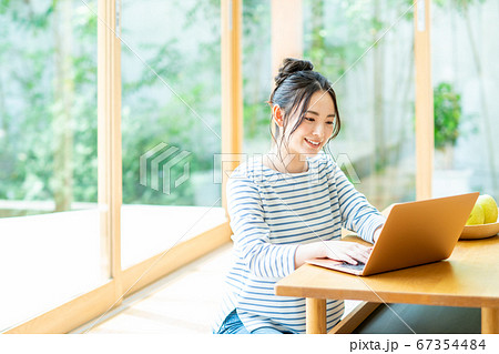 リビングでパソコンをする若い女性 67354484