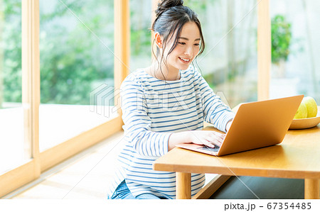 リビングでパソコンをする若い女性 67354485