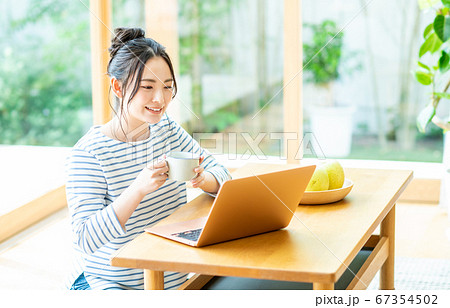 リビングでパソコンをする若い女性 67354502