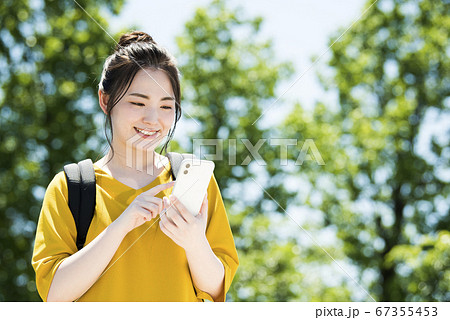 スマホを操作する若い女性 67355453