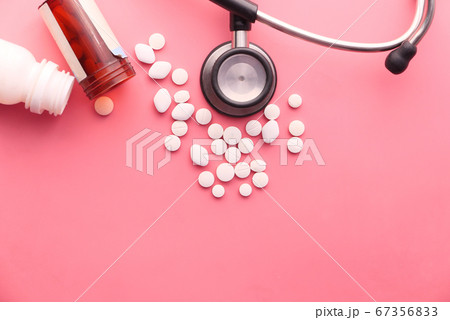 pills, stethoscope and container on pink background  67356833