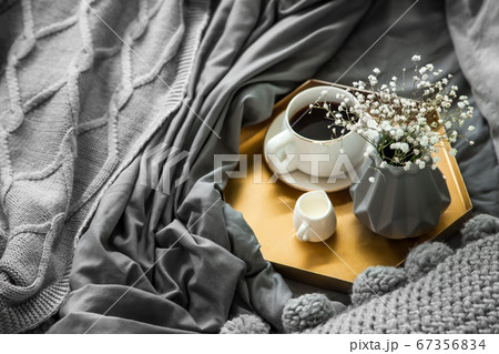 Cozy breakfast in bed, cup of coffeeand milk on the grey fabric, space for text. Breakfast in bed. 67356834