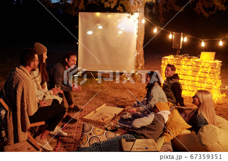 Group of young restful friends having pizza with drinks and discussing movie 67359351